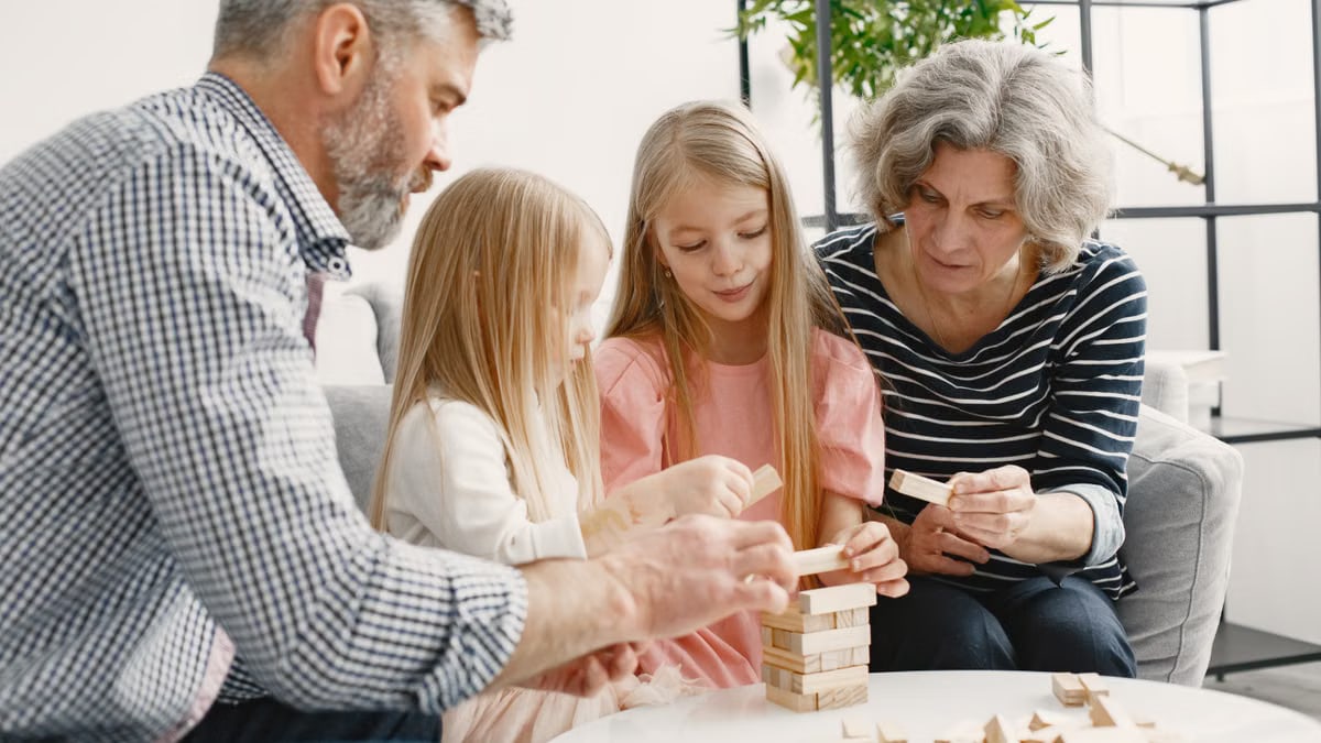 A family enjoying time together playing a block stacking game in their living room.