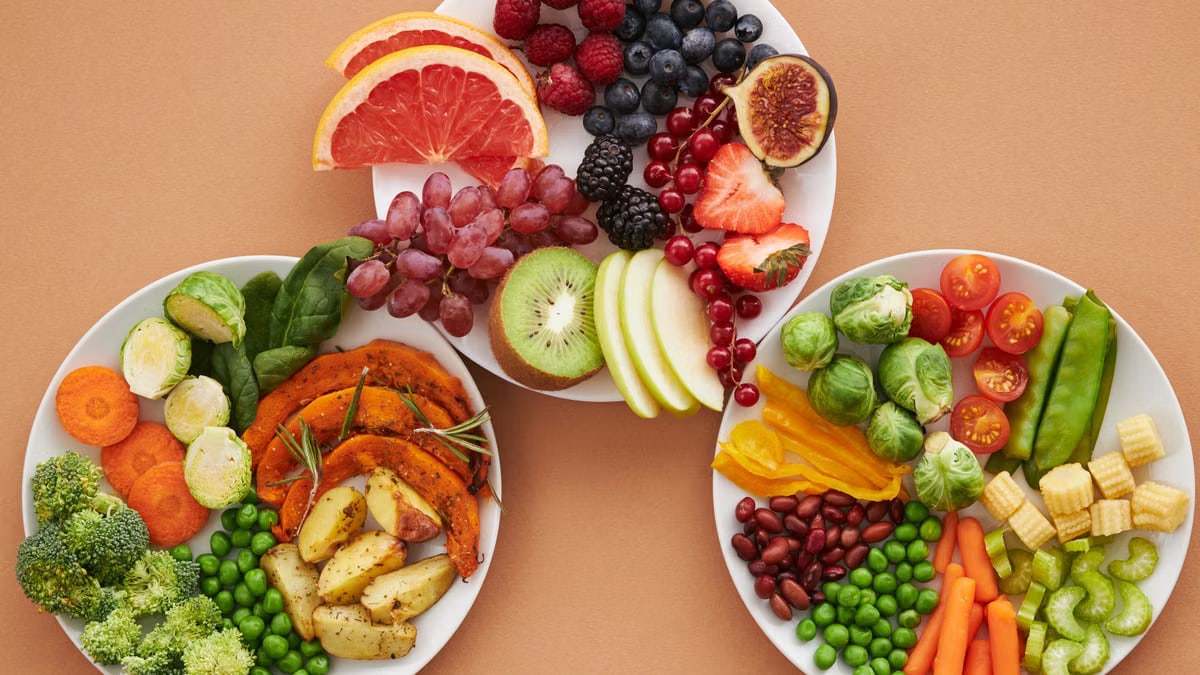 Top view of vibrant plates of fresh fruits and vegetables, perfect for a healthy lifestyle.